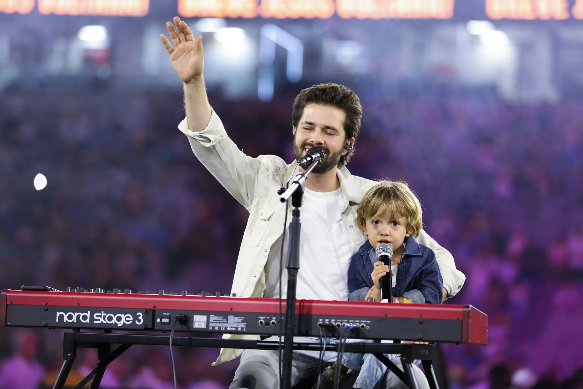 Matheus canta com o filho no colo, ao piano