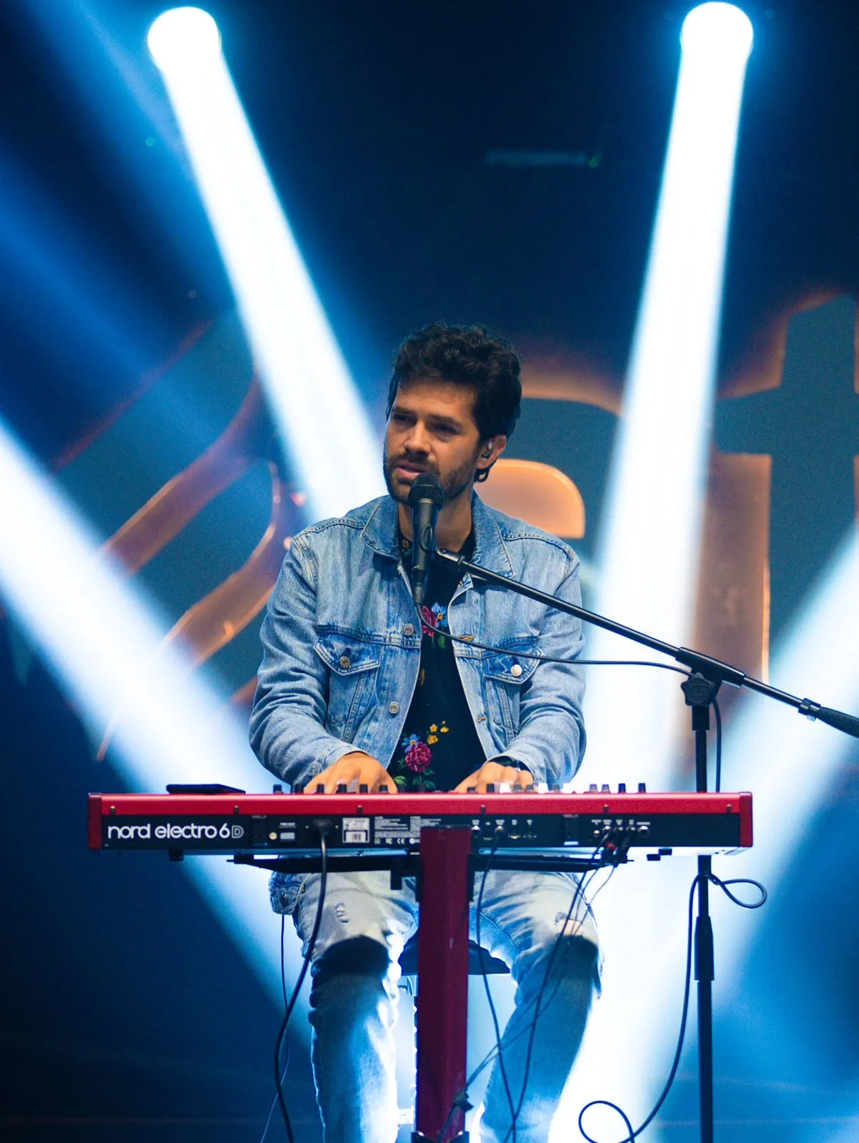 Matheus ao piano entre feixes de luz azul